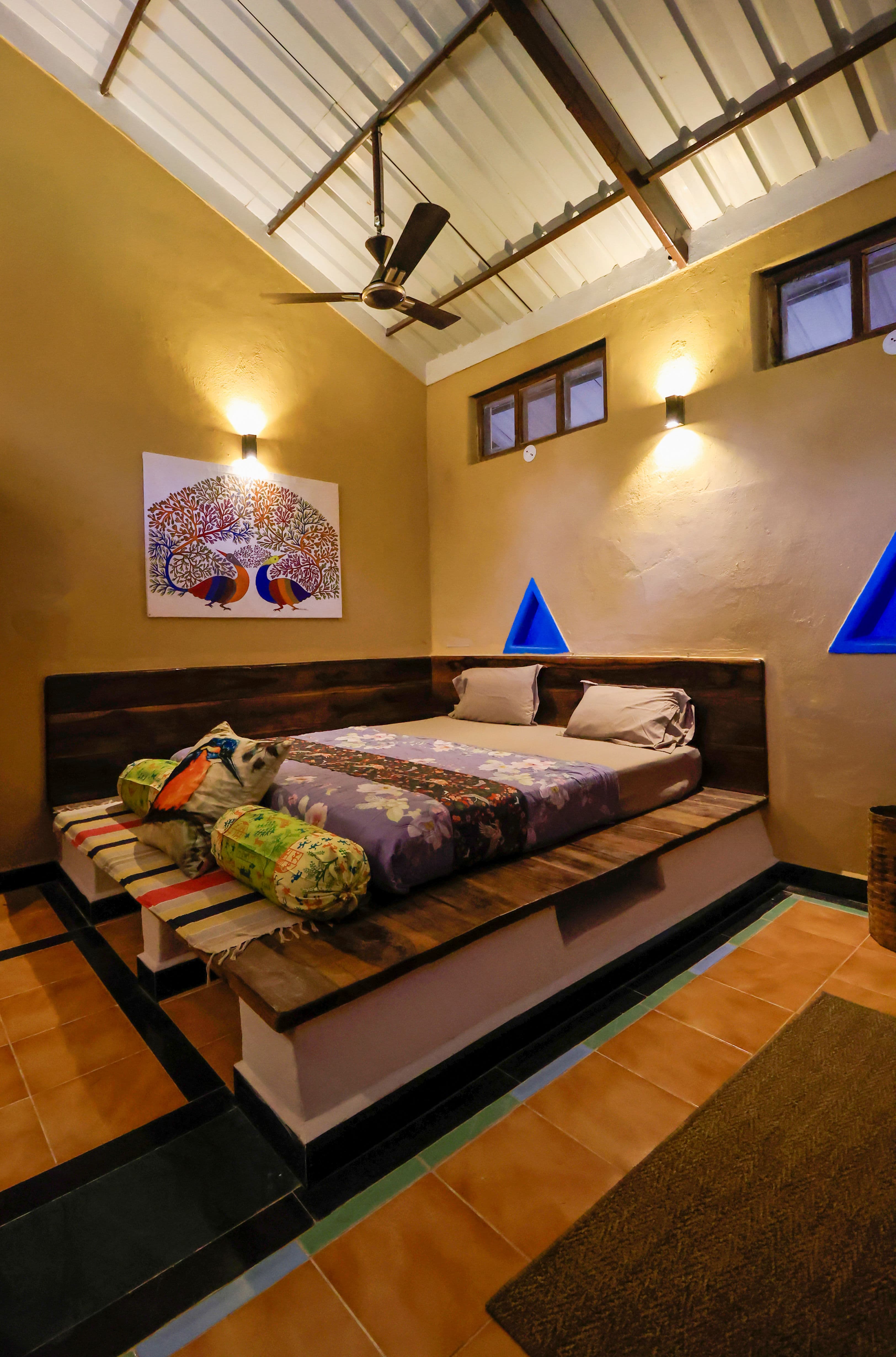 Spacious bedroom with king bed facing floor-to-ceiling forest view windows